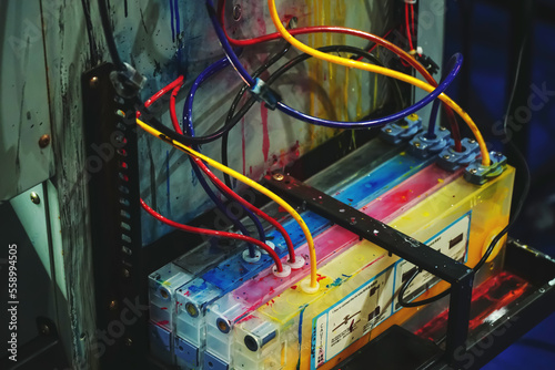 Close-up shot of a CMYK ink tank printer in industrial color printers that have been used. 