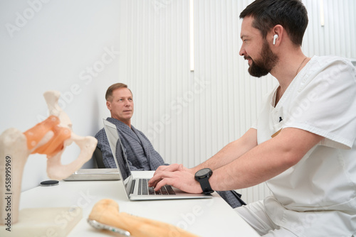 Professional male doctor receiving patient at his modern office