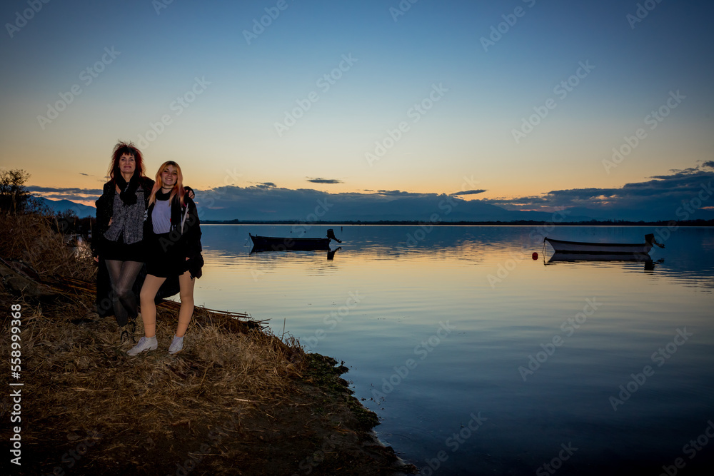 Femmes au bord de l' Étang de Canet-Saint-nazaire vers le Village de pêcheurs au coucher du soleil Femmes au bord de l' Étang de Canet-Saint-nazaire vers le Village de pêcheurs au coucher du soleil