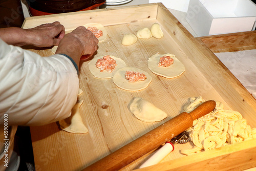 Woman prepares Apulian panzerotti on a wooden board photo