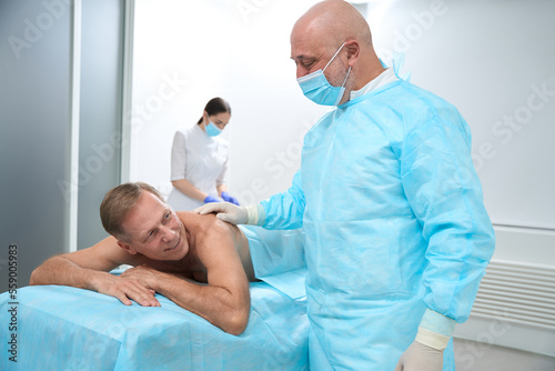 Middle-aged surgeon prepares a patient for a minimally invasive operation