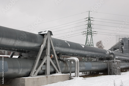 pipeline and power line in the city in winter against the gray sky.