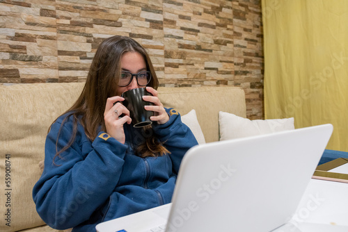 Girl drinks tea while working