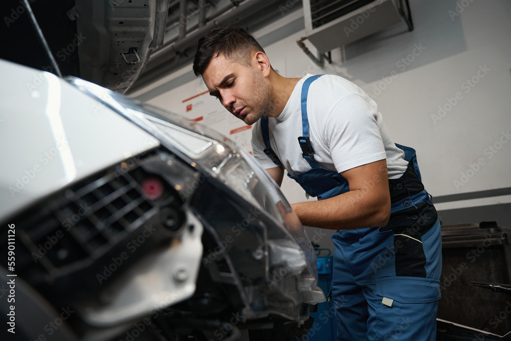 Technician doing technical inspection of car in tire shop Technician doing technical inspection of car in tire shop