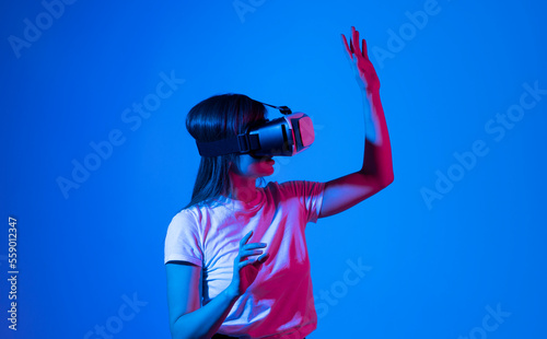 Woman getting experience in metaverse using VR headset glasses. Exploring a cyberspace via virtual reality.