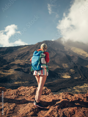 Rear view of hiker woman standing on slopes of Mt. Etna 