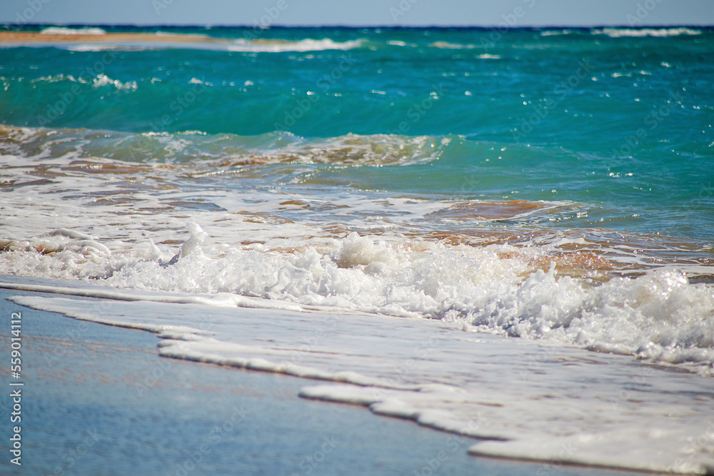 Waves gently crash onto the sandy beach