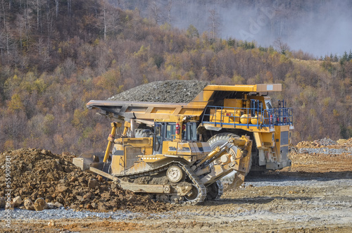 Crawler bulldozer working on construction site or quarry. Mining machinery moving clay  smoothing gravel surface for new road. Earthmoving  excavations  digging on soils