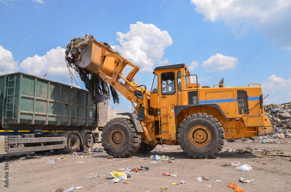 Wheel loader on landfill. Sorting rubbish by wheel loader 