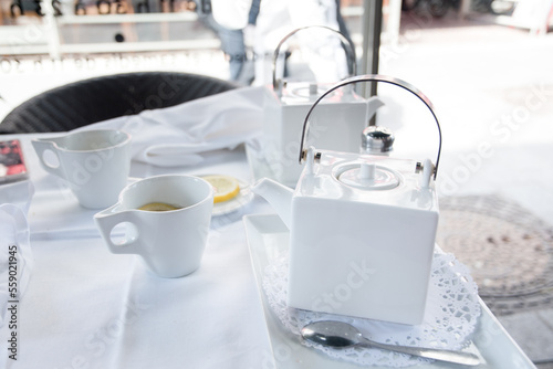 tea break with a white tea set at a table in a cafe in the city
