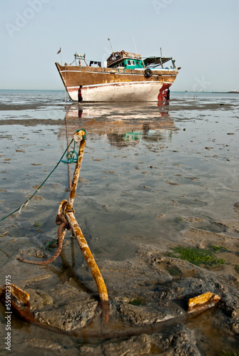 Fishing boat anchored on the sand waiting for the high tide, Bandar- Abbas, Iran photo