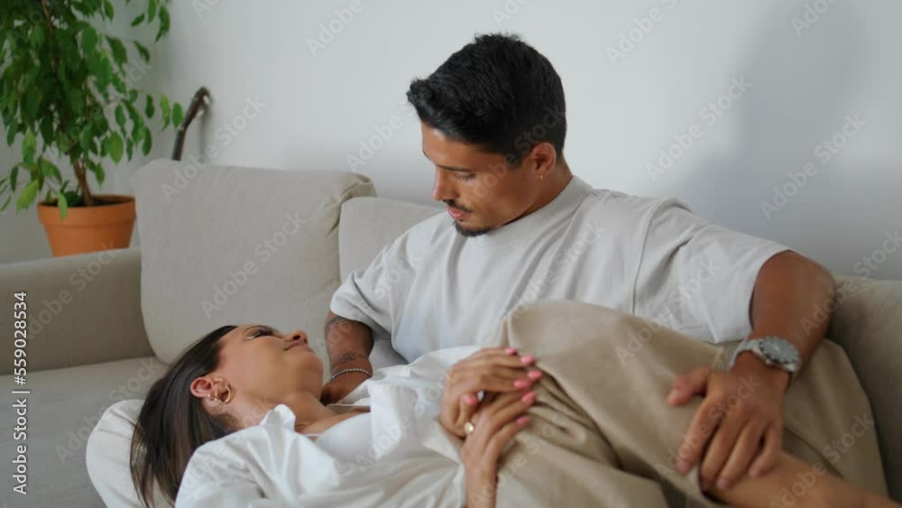 Passionate man stroking wife face at light room. Couple sharing dreams together