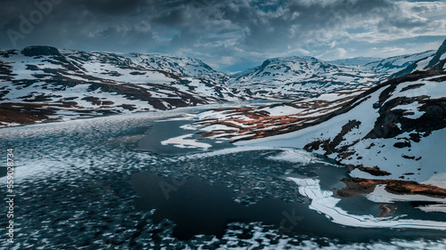 Snowy landscape of Hardangervidda national park with mountains and icy lakes in Norway, from above photo