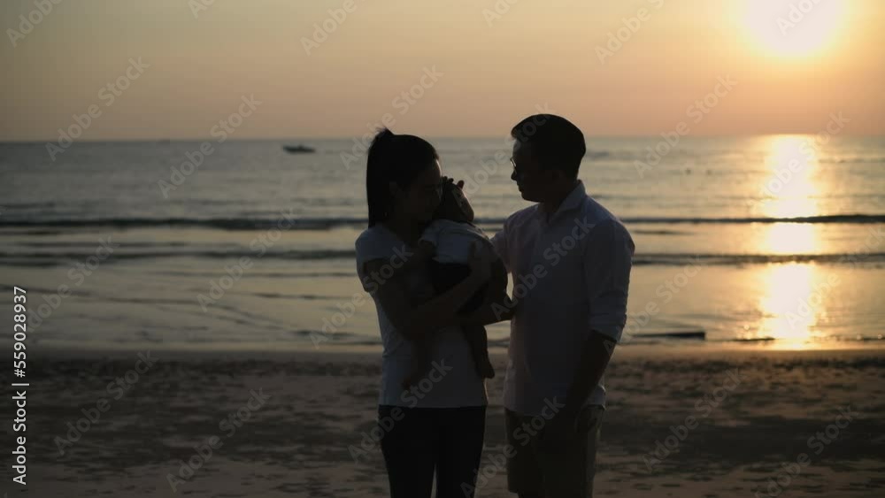 Tourism concepts of 4k Resolution. Silhouette of an Asian family relaxing on the beach. Tourism concepts of 4k Resolution. Silhouette of an Asian family relaxing on the beach.