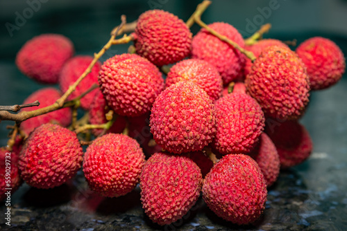 Ripe lychee fruit (Litchi chinensis) isolated in dark background and selective focus photo
