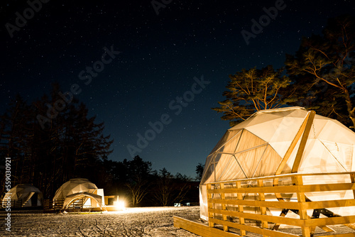 夜のキャンプ場のグランピング施設と冬の星空