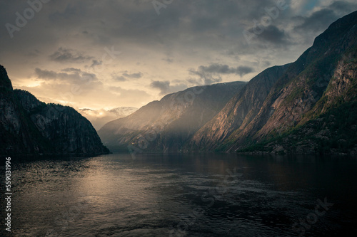 Sunset in the fjord and mountain landscape Eidfjord in Norway from above, sun rays falling through clouds