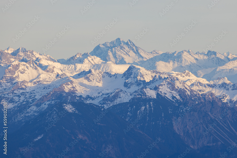 Obraz premium Shot from behind the peaks of the Swiss mountains during the golden hour, perfect for photography.