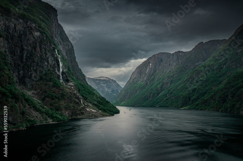 Moody fjord with mountains and waterfall of Aurlandsfjord at Gudvangen in Norway, dark clouds in the sky, from above photo