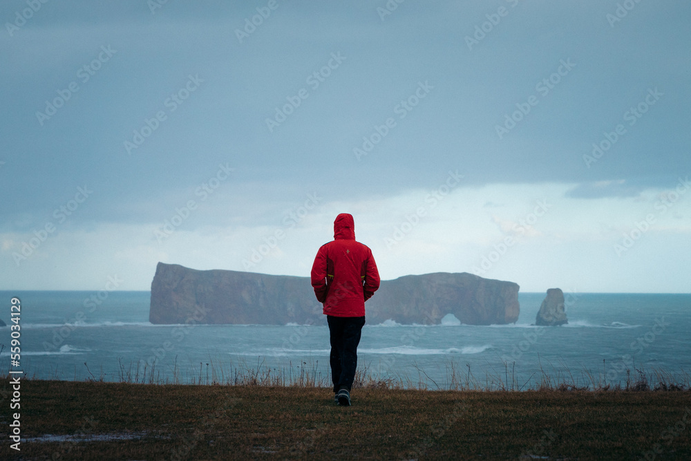 Obraz premium lonely person walking in front of the ocean on a rainy day