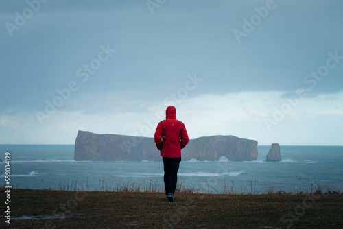 lonely person walking in front of the ocean on a rainy day