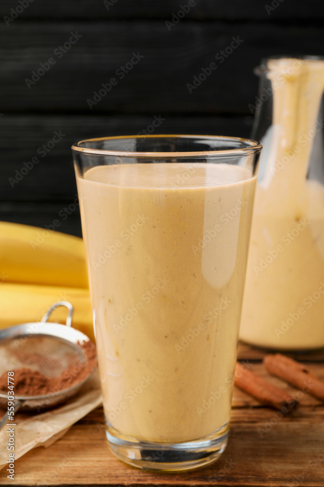 Tasty banana smoothie and ingredients on wooden table Tasty banana smoothie and ingredients on wooden table