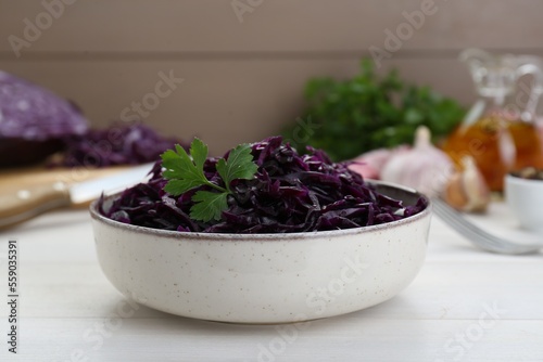 Tasty red cabbage sauerkraut with parsley on white wooden table