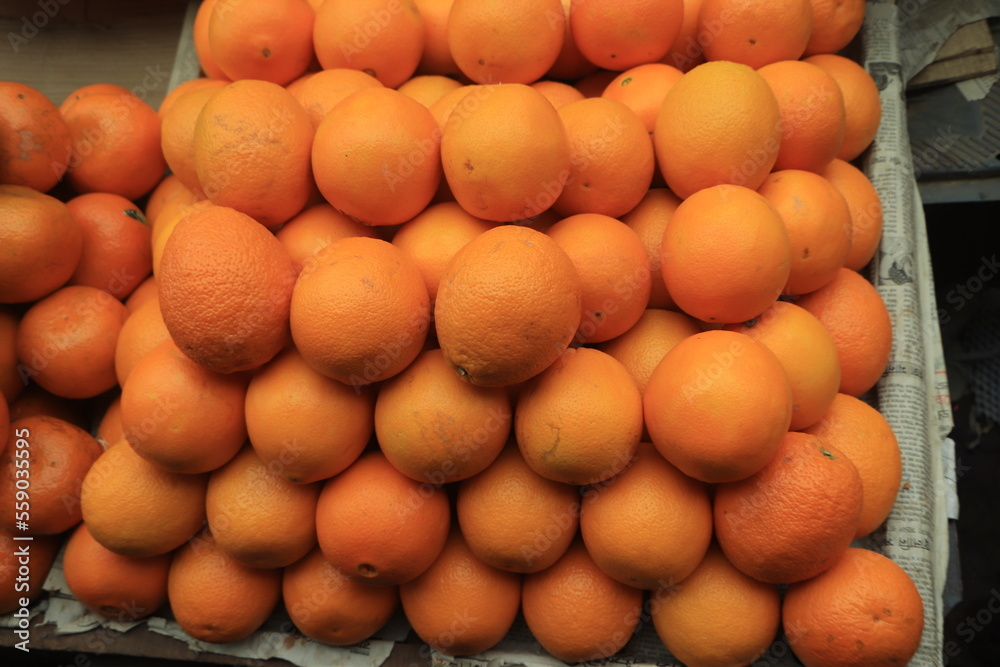 Fresh organic oranges on display on sunny day.