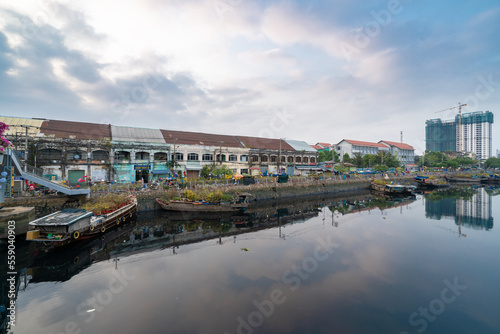 HOCHIMINH CITY, VIETNAM - JANUARY 29, 2022: Morning at Flower market on Tet holiday "Tren Ben Duoi Thuyen" every year at Binh Dong Wharf, District 8. Boats are shake by water, blur foreground