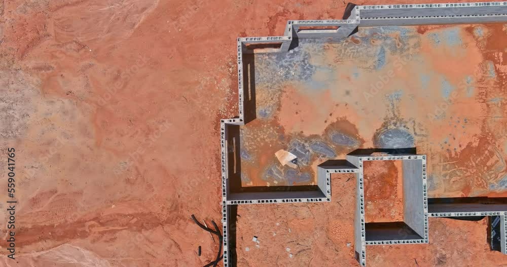 House under construction an concrete block bricks to wall for foundation on building site House under construction an concrete block bricks to wall for foundation on building site