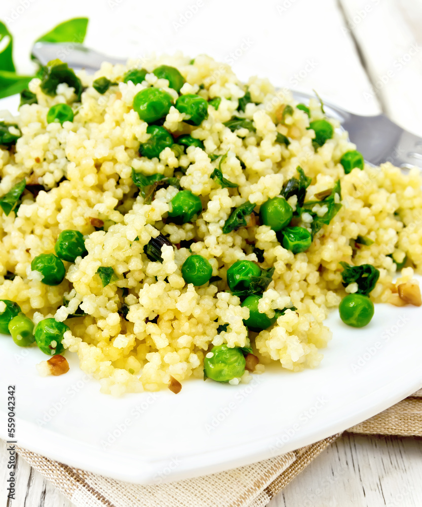 Couscous with spinach and green peas in dish on towel Couscous with spinach and green peas in dish on towel