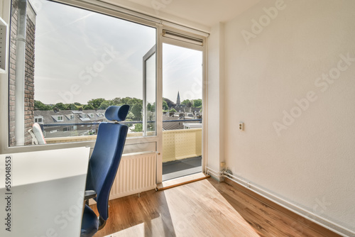 an empty room with a desk and chair in front of a window looking out onto the cityscapea photo