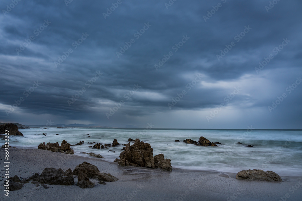 Wild, stormy weather, the waves blurred by the long exposure, at Skulpiesbaai along the Hermanus coastline, Whale Coast, Overberg, Western Cape, South Africa. Wild, stormy weather, the waves blurred by the long exposure, at Skulpiesbaai along the Hermanus coastline, Whale Coast, Overberg, Western Cape, South Africa.