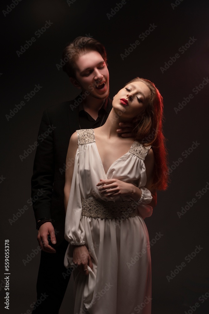 Vampire man with sensual female in white dress