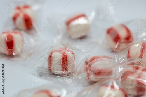 Macro abstract defocused view of wrapped peppermint candies on a white background