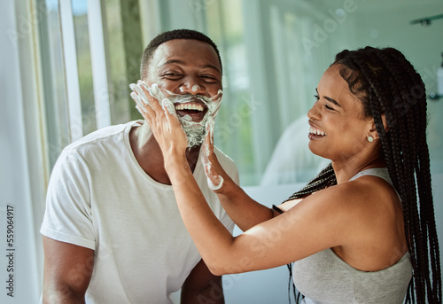Shaving, playful and fun with a black couple laughing or joking together in the bathroom of their home. Love, shave and laughter with a man and woman being funny while bonding in the morning