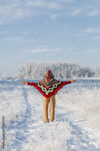 a man in a winter forest, alone in a poncho, a walk in nature