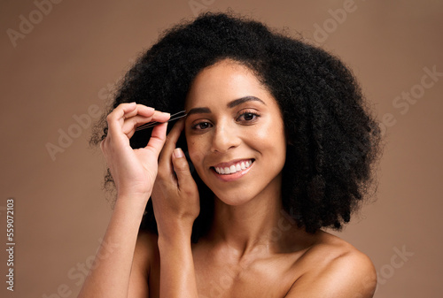 Face, makeup and eyebrow pencil with a model black woman in studio on a brown background for a beauty product. Portrait, cosmetics and eyes with an attractive female inside to apply a cosmetic brand