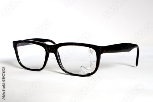 glasses with a dark frame, a broken lens on a white background
