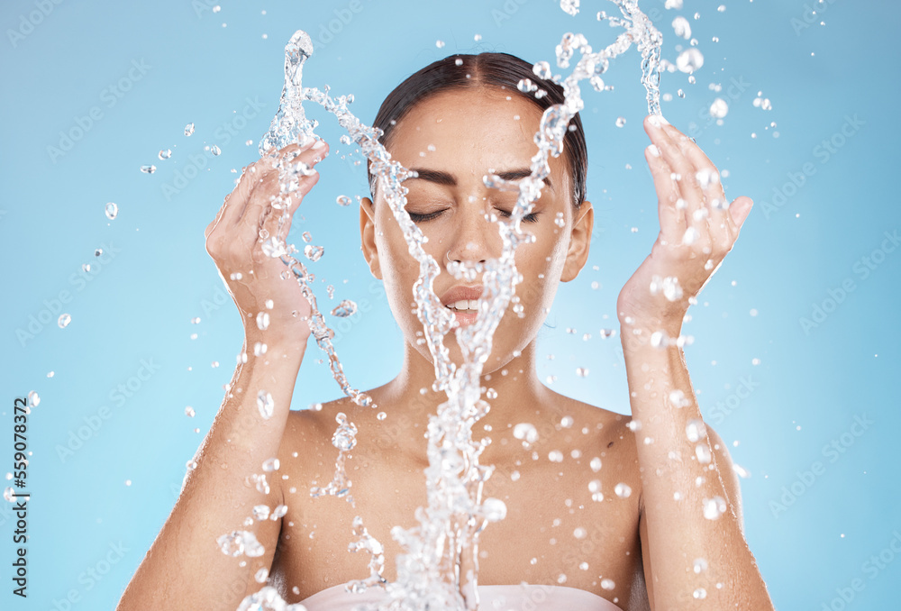 Woman, skincare or washing face with water splash on blue background studio for healthcare wellness, hygiene maintenance or bathroom grooming. Beauty model, hands or facial cleaning with water drops Woman, skincare or washing face with water splash on blue background studio for healthcare wellness, hygiene maintenance or bathroom grooming. Beauty model, hands or facial cleaning with water drops