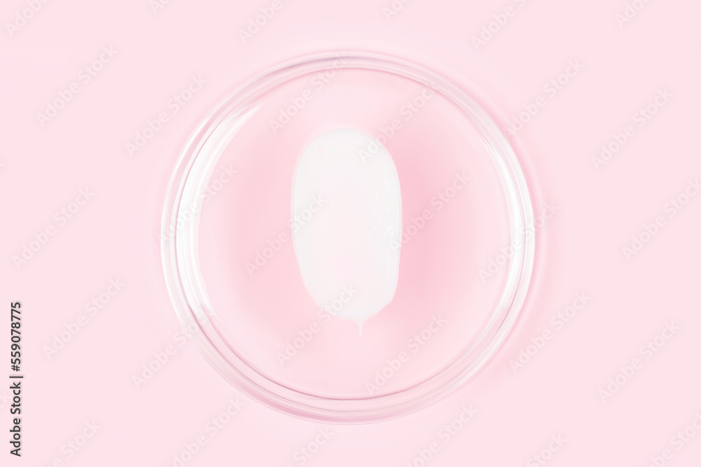 White cream smear. Silky texture of beauty product - face or eye cream, body lotion. White cream smudge over pastel pink background White cream smear. Silky texture of beauty product - face or eye cream, body lotion. White cream smudge over pastel pink background