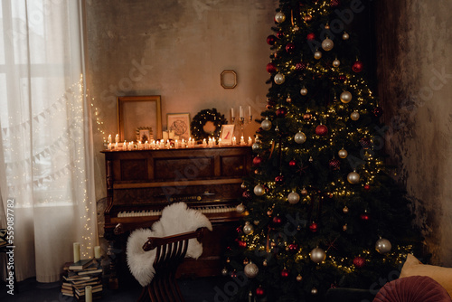 tree in the living room. Beautiful Christmas room with Christmas tree and piano candles