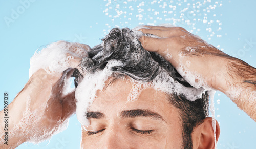 Quadro su tela Face, water splash and shampoo shower of man in studio isolated on a blue background