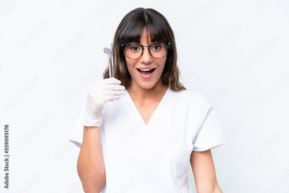 Dentist caucasian woman holding tools isolated on white background with surprise facial expression Dentist caucasian woman holding tools isolated on white background with surprise facial expression