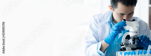 фотографія Lab assistant, a medical scientist, a chemistry researcher holds a glass tube through the blood sample, does a chemical experiment and examines a patient's blood sample