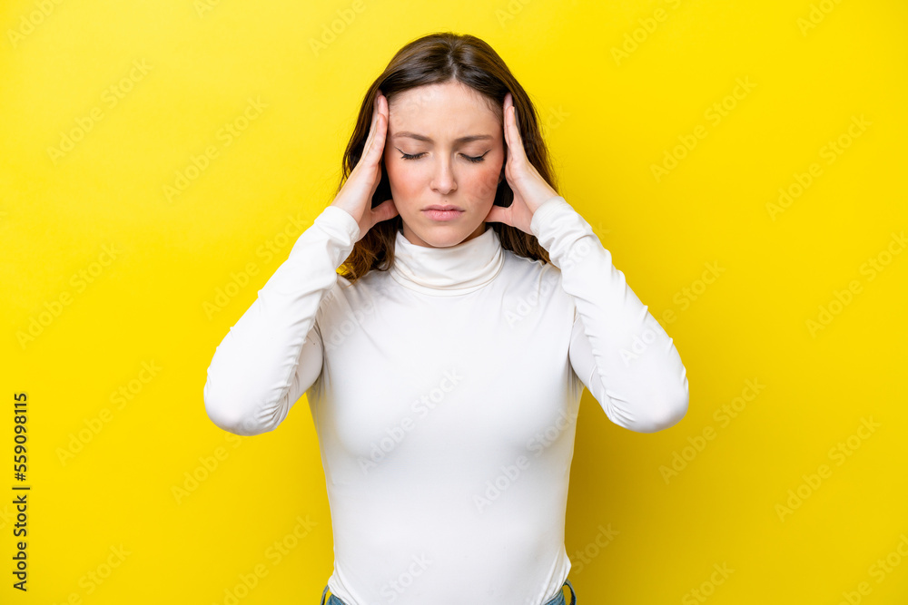Young caucasian woman isolated on yellow background with headache Young caucasian woman isolated on yellow background with headache