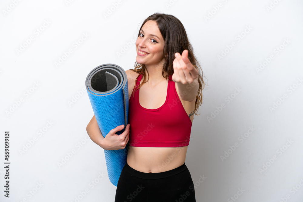 Young sport caucasian woman going to yoga classes while holding a mat isolated on white background making money gesture