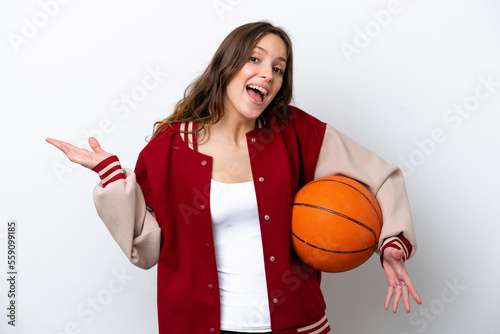 Young caucasian woman playing basketball isolated on white background with shocked facial expression