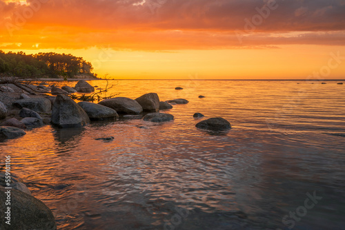 Fototapeta Naklejka Na Ścianę i Meble -  Wonderful orange sunset on the rocky coast of the sea