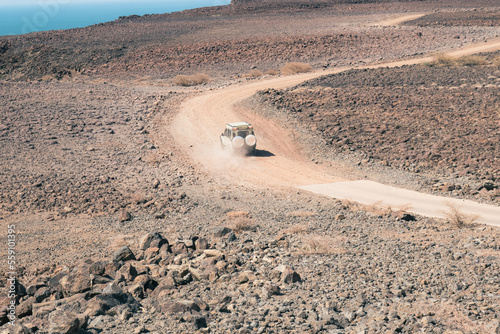 A tourist safari van in the desert landscapes of Lake Turkana in Loiyangalani District, Kenya photo